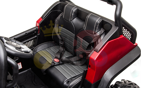 The Red 12V/4X4 Official Mercedes Unimog Junior Ride On UTV features red and black detailing, a black interior, two seats with seatbelts, a steering wheel, visible seat stitching, and an off-road design for adventurous young drivers. It includes remote control functionality.