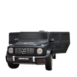 The Limited 12V Matte Edition Mercedes Benz AMG G63 Kids and Toddlers Ride-On Truck, RC, is a black luxury ride-on car featuring detailed headlights, a distinctive grille, and open side doors. With upgraded technology, it mirrors the elegance of the iconic G-Class SUV.