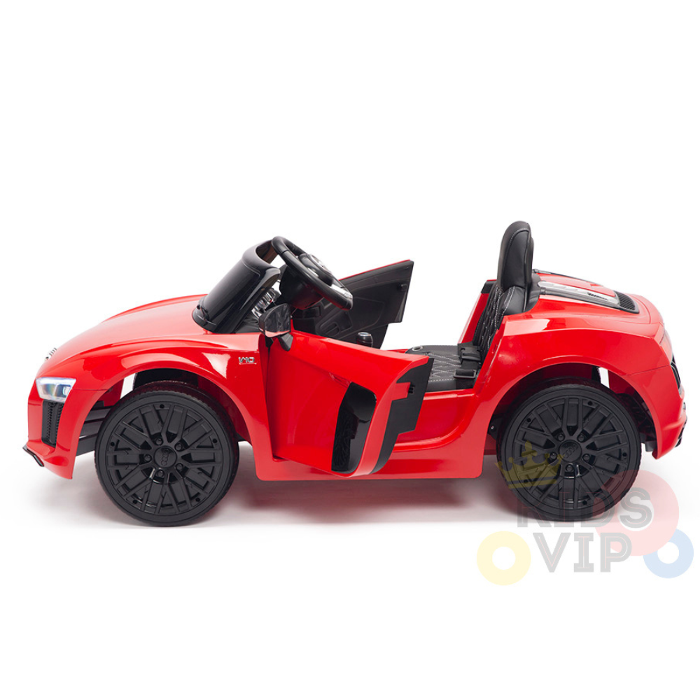 The Red 12V Audi R8 Licensed Ride-On Car features an open drivers door, sleek black interior with a steering wheel, and black upgraded EVA rubber wheels. This battery-powered toy is designed for childrens delight and showcases vibrant colors against a crisp white background.