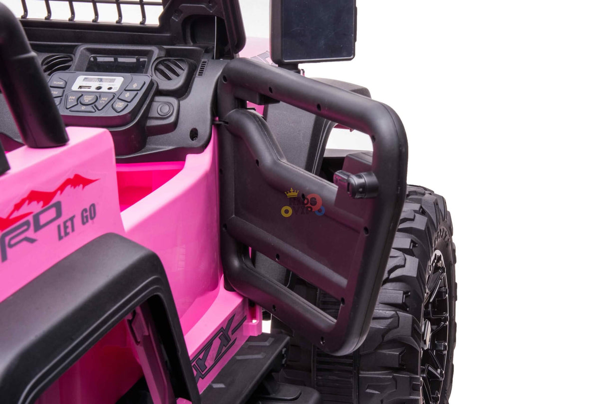Close-up of a pink toy ride-on car with a black interior, steering wheel, dashboard, and an open door showing a closing knob. Large off-road tires feature on this kids 24V/4WD Xtreme Ride-on Truck with Eva wheels, leather seats, and parental remote control for safety.