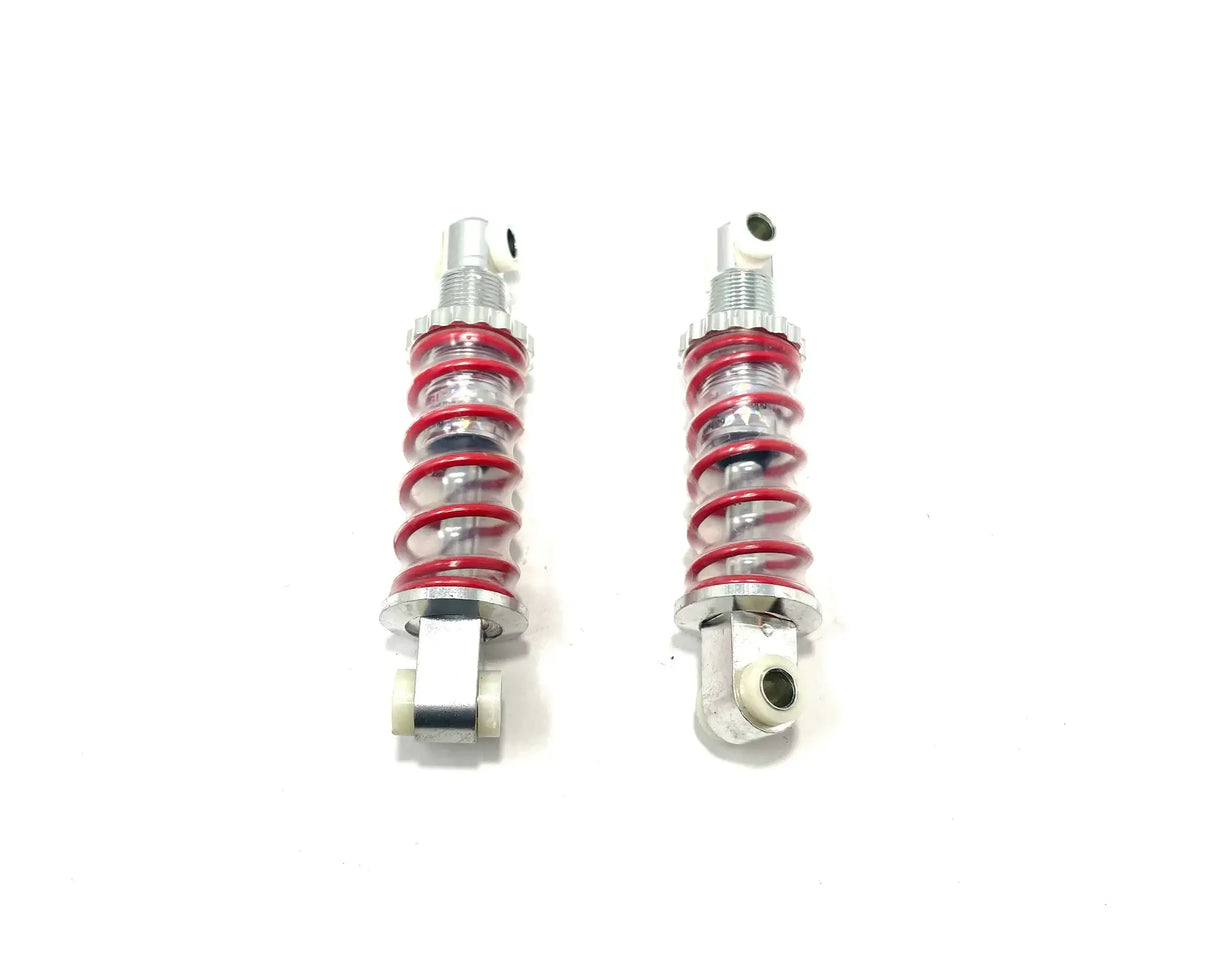 Displayed against a white background, the 12V UTV Sport XMX Suspension Shocks feature two silver bodies with vibrant red springs and mounting points at each end. Ideal for ride on cars, they are final sale items. Contact us for more details!.