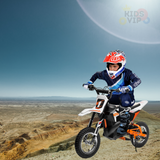 A person in motocross gear and helmet rides the 24V/250W SuperMoto Off Road Edition Dirt Bike across rocky terrain under a clear blue sky, embracing the spirit of off-road adventures.