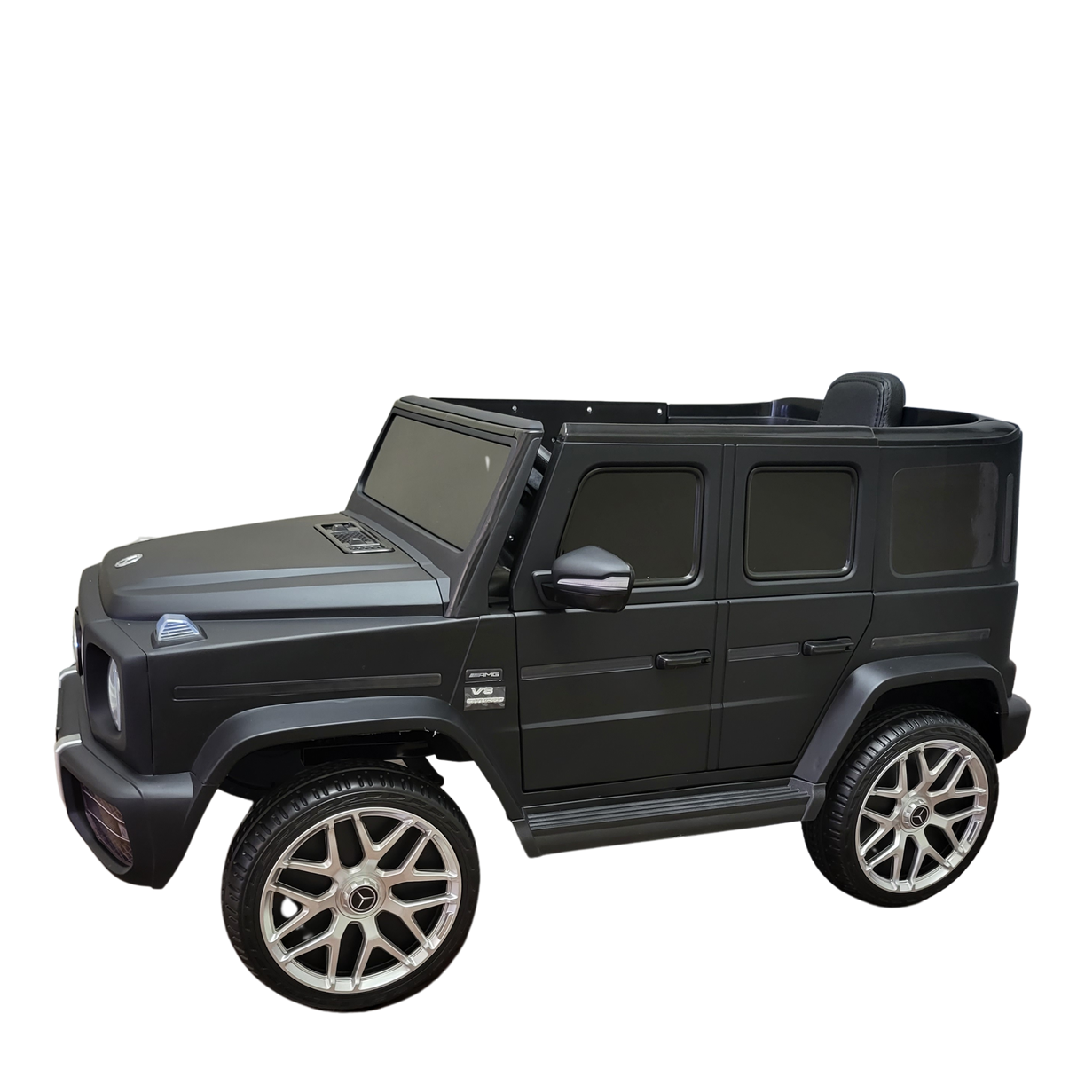 The Limited 12V Matte Edition Mercedes Benz AMG G63 Kids and Toddlers Ride-On Truck, RC, is a sleek black replica SUV with silver rims, side mirrors, and a hood ornament, offering upgraded technology to mimic a luxurious miniature vehicle.