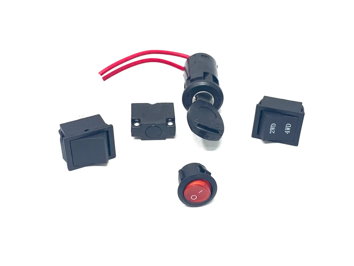 The 12V UTV Sport XMX Set Of Switches includes five assorted electronic switches—toggle, rocker, and push-button types—ideal for customizing your ride-on car. One has a red button, some include red wires, and all are final sale with no refunds. Displayed against a plain white background.