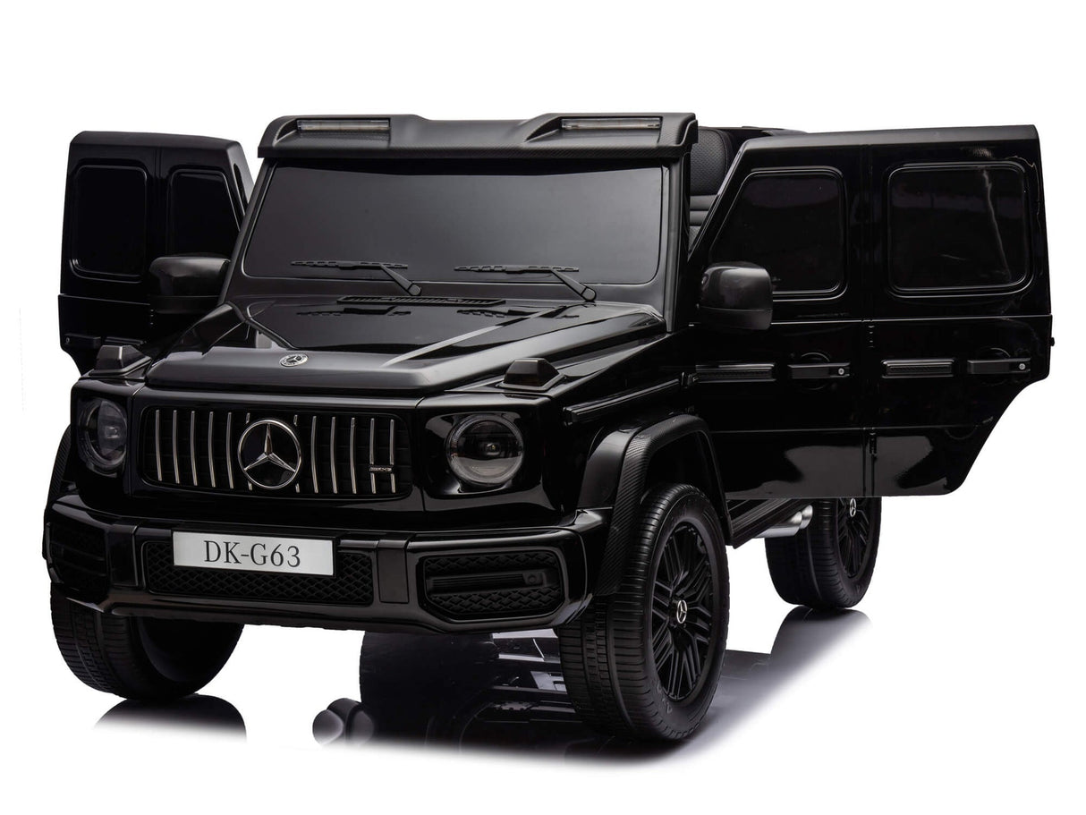 A toy model of the Black Mercedes G63 XXL 24V Kids Ride-On Truck - Platinum Edition is shown with open front doors, detailed wheels, headlights, and a DK-G63 license plate on the bumper. It captures the essence of an MP4-equipped ride-on with dual batteries and EVA tires.