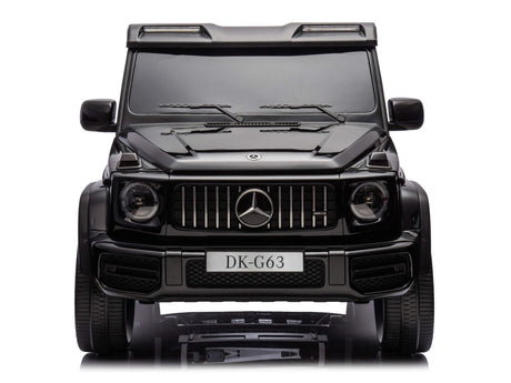 Front view of a Black Mercedes G63 XXL 24V Kids Ride-On Truck – Platinum Edition. It features a detailed grille, headlights, logo on the hood, and DK-G63 license plate. Windshield wipers enhance the realism of this 4WD ride-on truck with EVA tires and leather seats against a white backdrop.