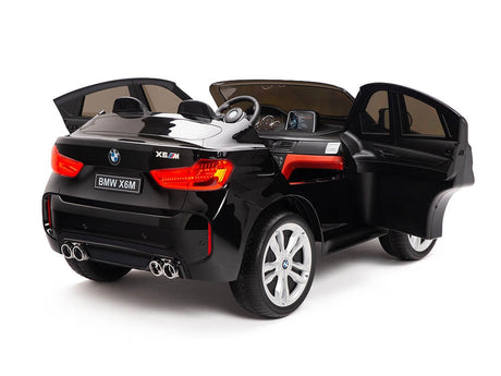 The Black 12V Licensed XXL BMW X6 Ride On Car offers kids a stylish ride with open doors, detailed interior, dual exhaust, and silver wheels. Featuring seating for two, it includes a steering wheel and dashboard for an authentic driving experience.