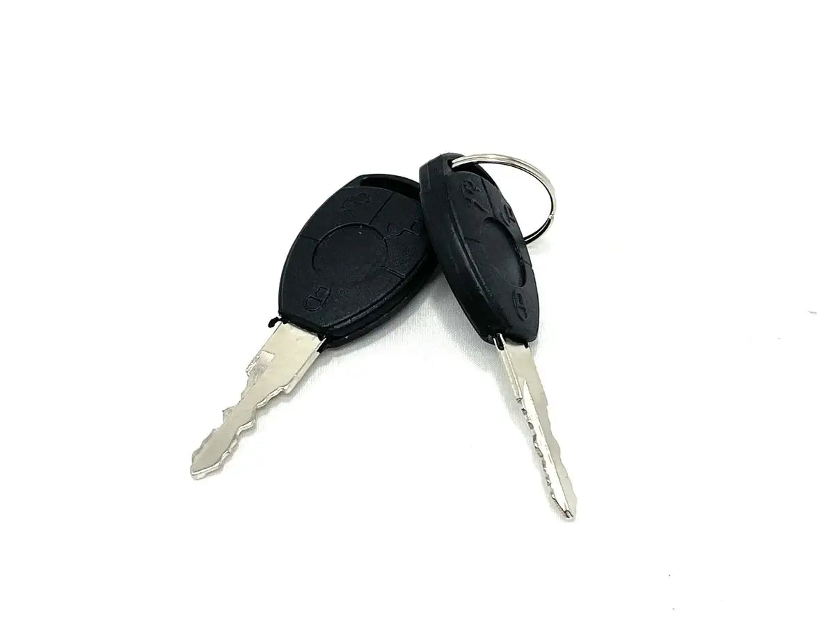 The 12V McLaren 720 set of keys includes two car keys with black plastic fobs, similar to ride-on car keys, attached to a metal keyring. The jagged-edged keys overlap slightly on a plain white background.