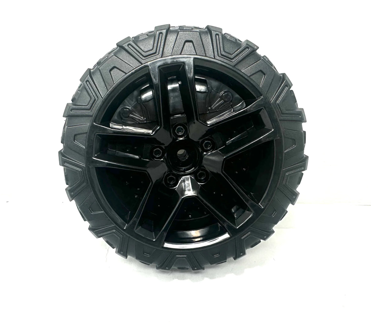 A shiny black alloy 12V Chevrolet Tire with an aggressive tread is perfect for off-road adventures. Featured on a ride-on car, this rugged design is a final sale exclusive at kidsviponline, showcased against a plain white background for maximum impact.