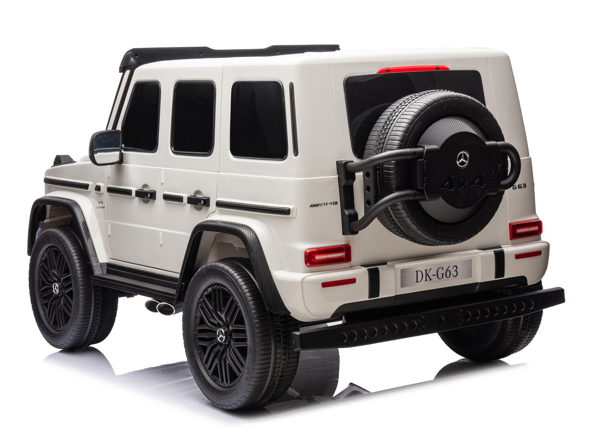 A toy-sized, white Mercedes G63 Ride-On Truck with black detailing, LED headlights, visible spare tire, reflective surface display resembles the classic design of the White 2x24V/4WD Platinum XXL Mercedes G63 with MP4, EVA Wheels & Leather Seats.