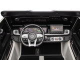 The dashboard of this luxury ride features a Mercedes-Benz logo on the steering wheel, digital displays, and a sleek black and white interior, offering remote access similar to the White 2x24V/4WD Platinum XXL Mercedes G63 Ride-On Truck with MP4, EVA Wheels & Leather Seats for seamless connectivity.