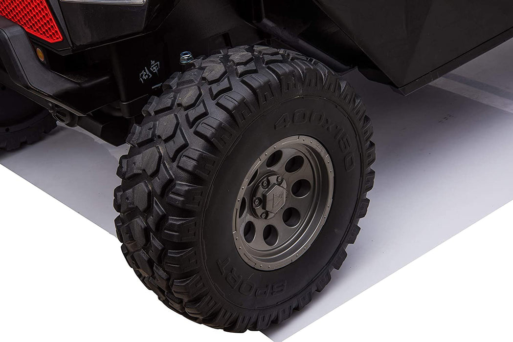 Close-up of the durable rubber wheels on a Camo 24V/4X4 Dune Buggy Ride On UTV, mounted on a metal rim against a smooth backdrop, highlighting its robust design for challenging terrains—ideal for adventurous rides.