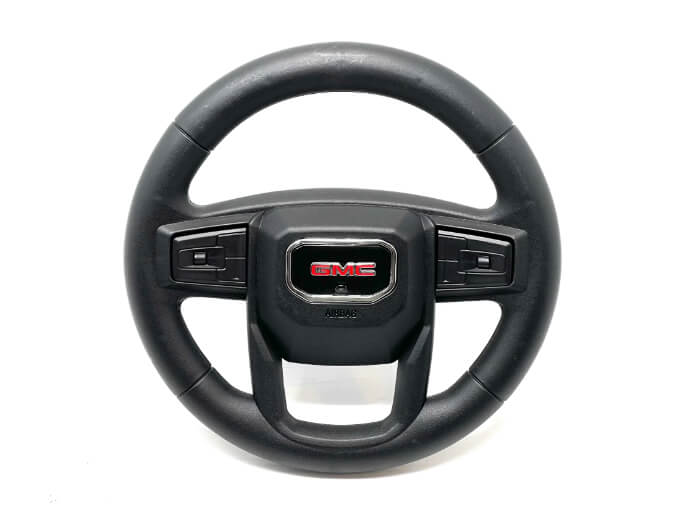 The Enhance Your 12v/2 Seater GMC Sierra with a High-Quality Steering Wheel features a black wheel, highlighting a red GMC logo in the center. With three robust spokes and a glossy finish, it mimics the style of modern vehicles.