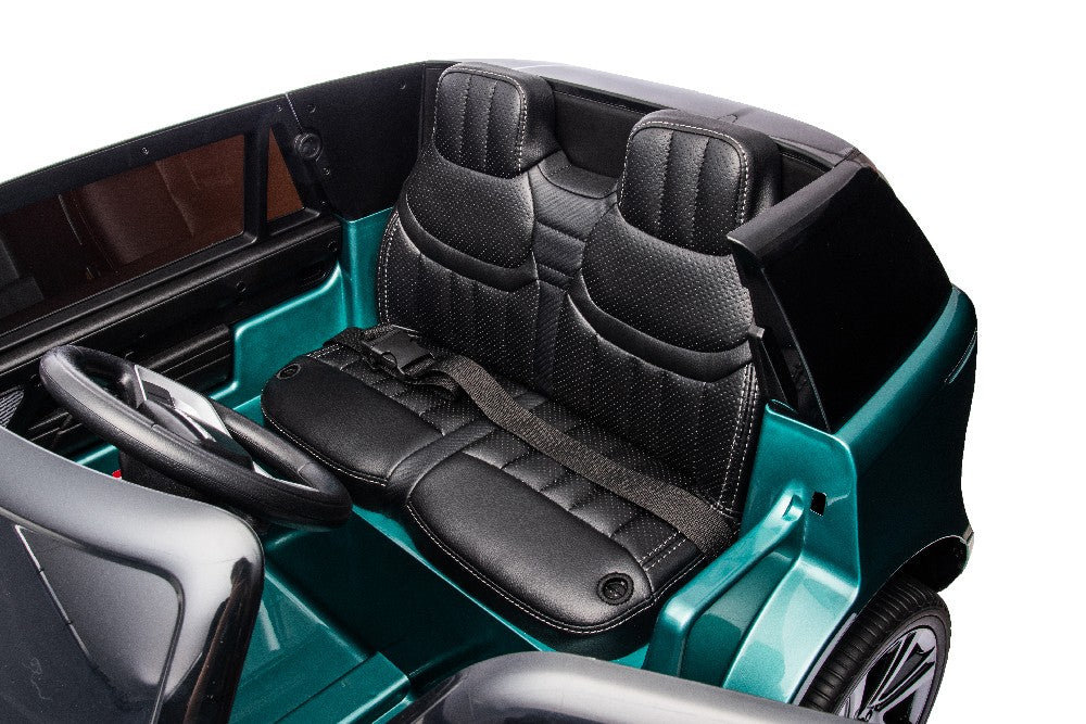 Inside the Green Metallic 24V Kids Range Rover, youll find luxurious black leather-like double seats with detailed stitching and seat belts. The dashboard and steering wheel standout beautifully against its striking teal exterior.