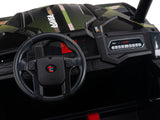 Close-up of a dashboard and steering wheel in the Camo 2 Seats Golf Buggy 24V Edition Ride-On Car. The dashboard has buttons, a digital display, and Rover. The steering wheel features a circular emblem with t and e. Interior is mainly black with green accents.