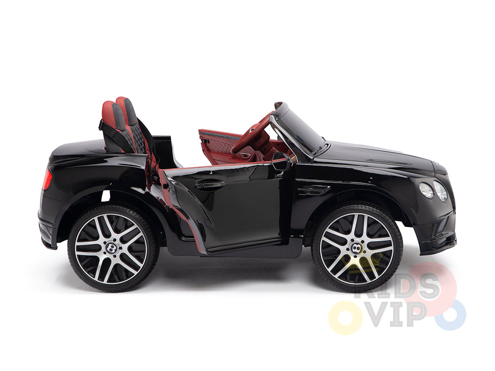 A sleek Black 12V Bentley GTC Kids Licensed Ride-On Car with red interior, open door, detailed wheels, and a steering wheel is shown from the side. The KIDS VIP logo is partially visible in the background.