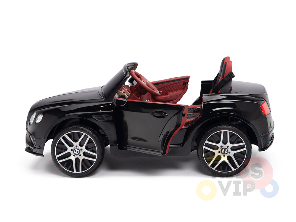 A Black 12V Bentley GTC Kids Licensed Ride-On Car with rubber wheels, featuring an open drivers door, red interior, silver rims, black steering wheel, and realistic details. Perfect as a ride-on or remote-controlled car. Displayed in profile against a white background.