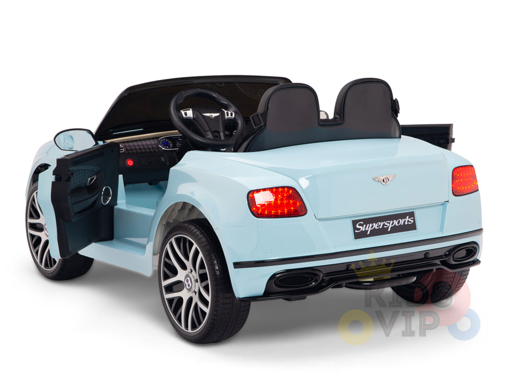 The Blue 12V Bentley GTC Kids Licensed Ride On Car features an open drivers door, plush leather seats, a detailed interior, Supersports rear label, and illuminated red taillights. It includes rubber wheels and a remote control for enhanced child-friendly fun.