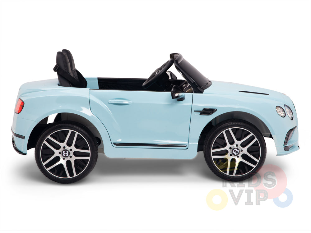 A light blue Bentley GTC Kids Ride On Car with a black leather seat and large silver rims, styled like a luxury vehicle with steering wheel, side mirrors, and detailed vents. The Kids VIP logo enhances this 12V remote control car for an upscale playtime experience.