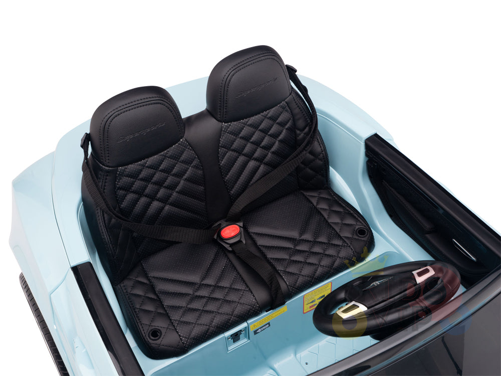 Meet the Blue 12V Bentley GTC Kids Licensed Ride On Car, featuring a luxurious quilted black leather seat, dual seat belts, and a steering wheel. This remote-controlled car gleams in light blue with rubber wheels, offering style and safety for young adventurers.