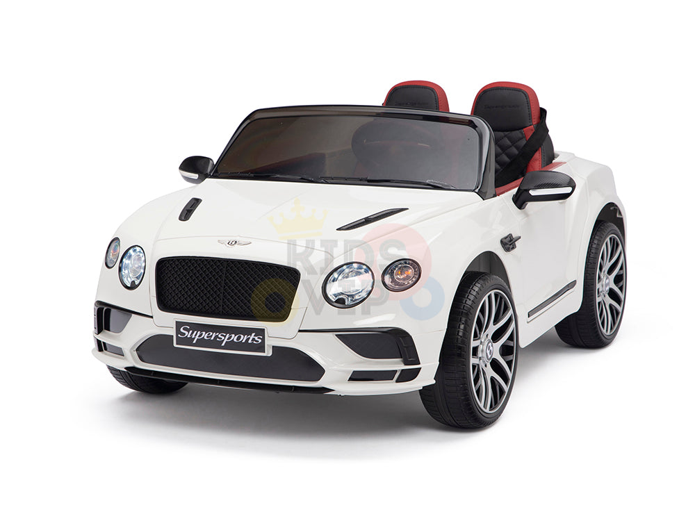 The White 12V Bentley GTC Kids Licensed Ride On Car boasts a sports design with black grille and side mirrors, red-accented leather seats, rubber wheels, and dual seating. The Supersports label adorns the front bumper.