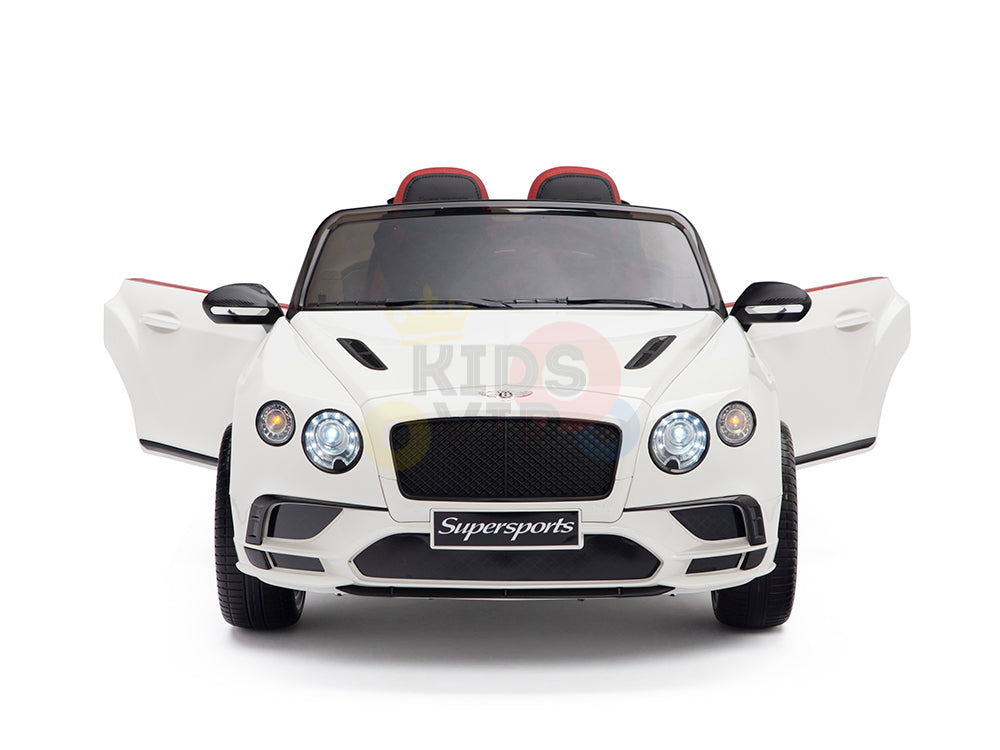 A front-view white Bentley GTC ride-on toy car with doors open, detailed grille, headlights, and two seats with red accents. This 12V remote control car is labeled Supersports.