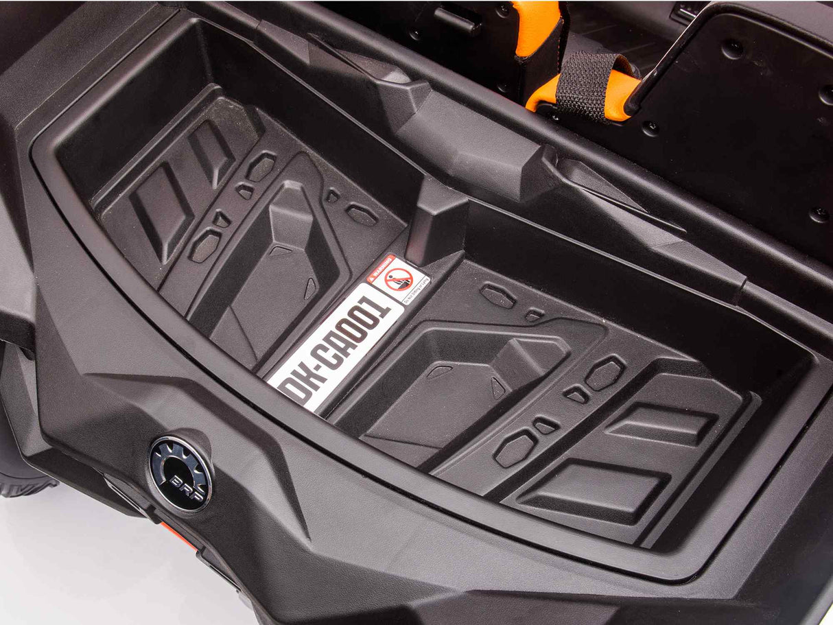 Close-up of a black plastic storage compartment in the Orange 2x24V/2WD Official Can-Am Maverick Ride on Buggy, LX Performance, with a textured surface and a label reading OH-C4001. A small ignition switch is on the left side, while an orange handle is partially visible at the top right.