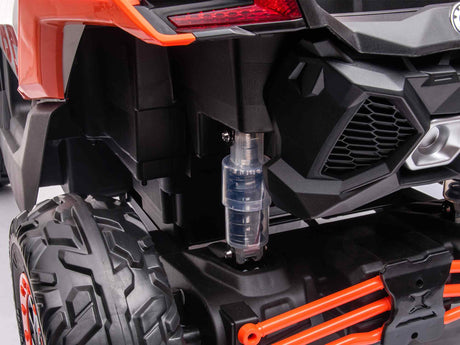 Close-up of the rear section of the 2 Seater Official 2x24v Can-Am Maverick RS Ride on Buggy, LX Performance 4WD Edition, featuring large textured black tires, an orange suspension component, a visible clear plastic cylinder, and a body with angular black and orange elements.