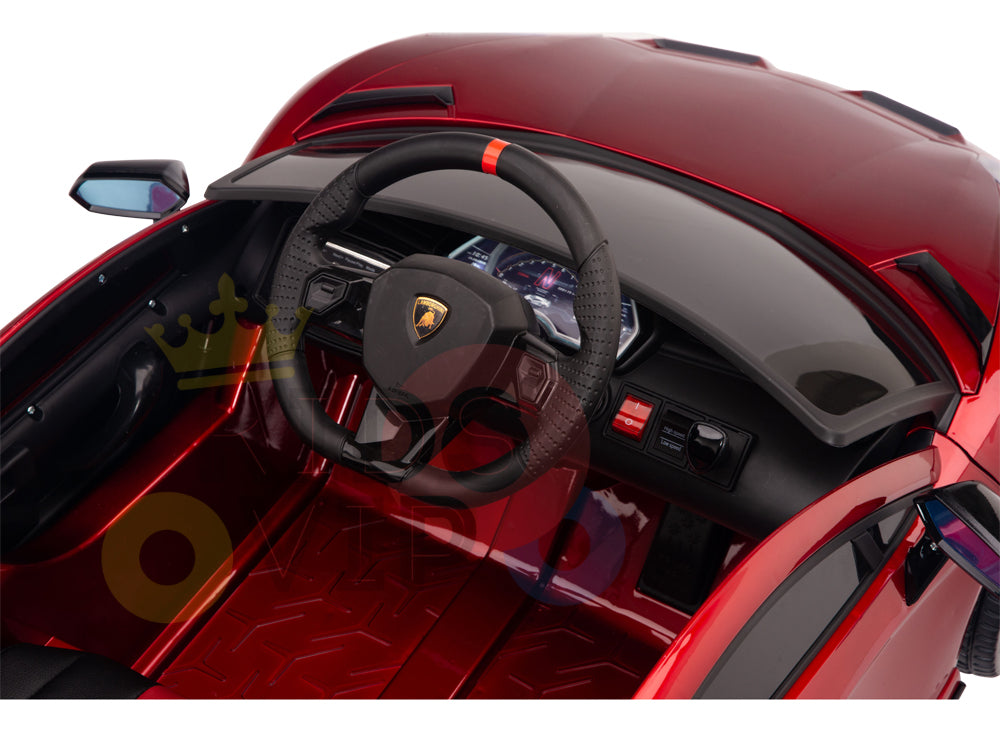 Interior view of a luxury Lamborghini Ride On Car with a black steering wheel featuring red detailing, buttons and gauges on the dashboard, and black seats. The Burgundy Red 12V Lamborghini SVJ Sport boasts two side mirrors and offers an exciting remote control experience for kids.