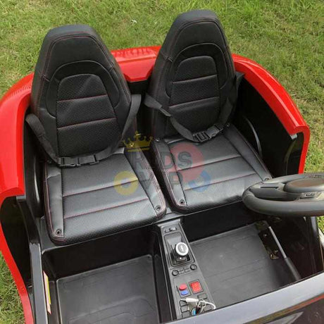 The Orange 24V XXL SuperSport Big Kids Ride On Car, with air-filled tires and a 180W brushless motor, features two black seats and a dashboard with buttons and steering wheel. Sunlight illuminates it as it sits on the grass.