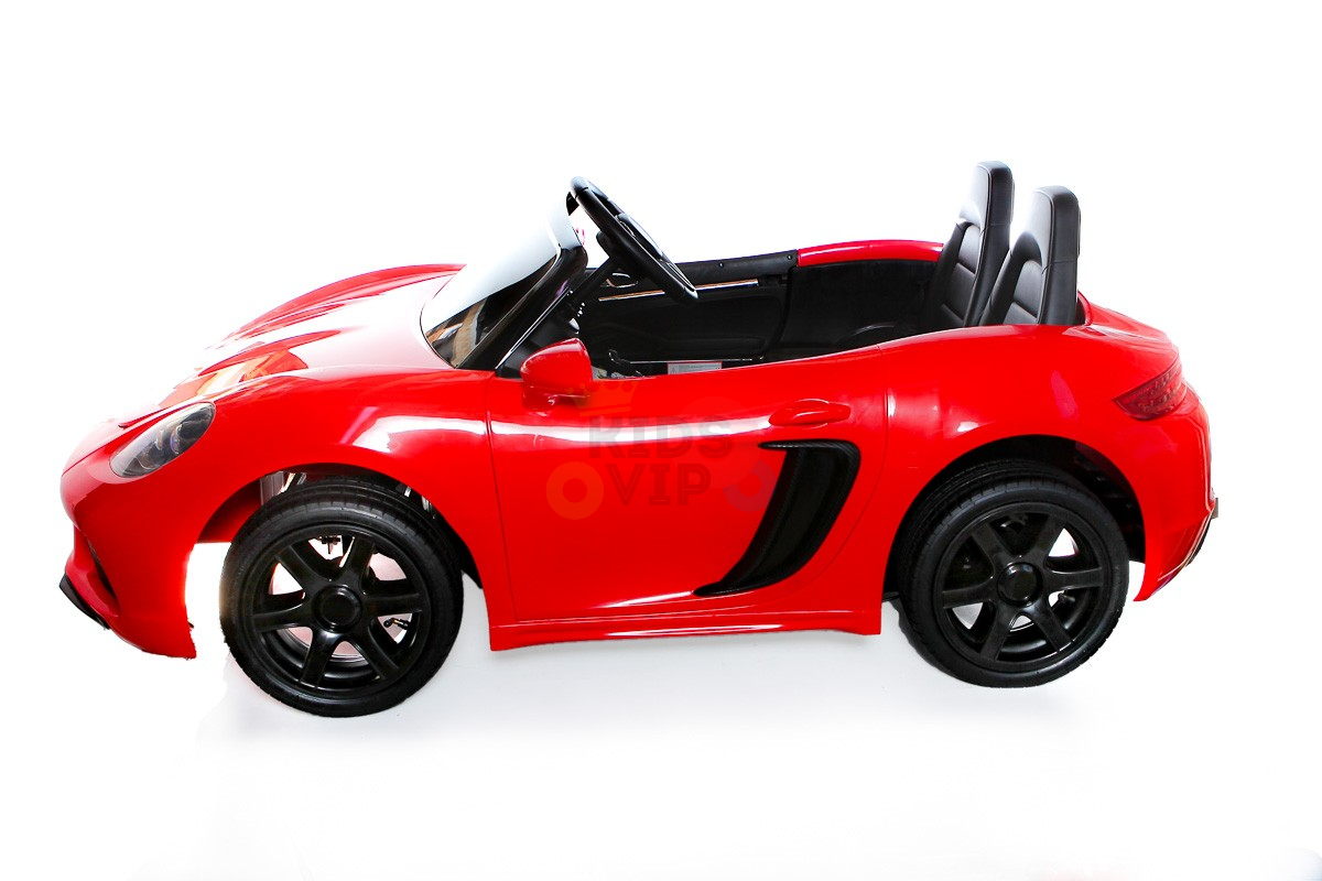 A Red 24V XXL SuperSport Big Kids Ride On Car with an aerodynamic design is shown in profile. It features black real tires, two seats, and a steering wheel, all powered by an exhilarating 180W brushless motor.