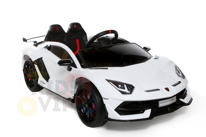 The White 12V Lamborghini SVJ Sport Ride-On Car for kids features sporty design elements, a detailed steering wheel, and sleek black and red details, capturing the essence of a luxury sports car. It includes rubber wheels and a remote control.
