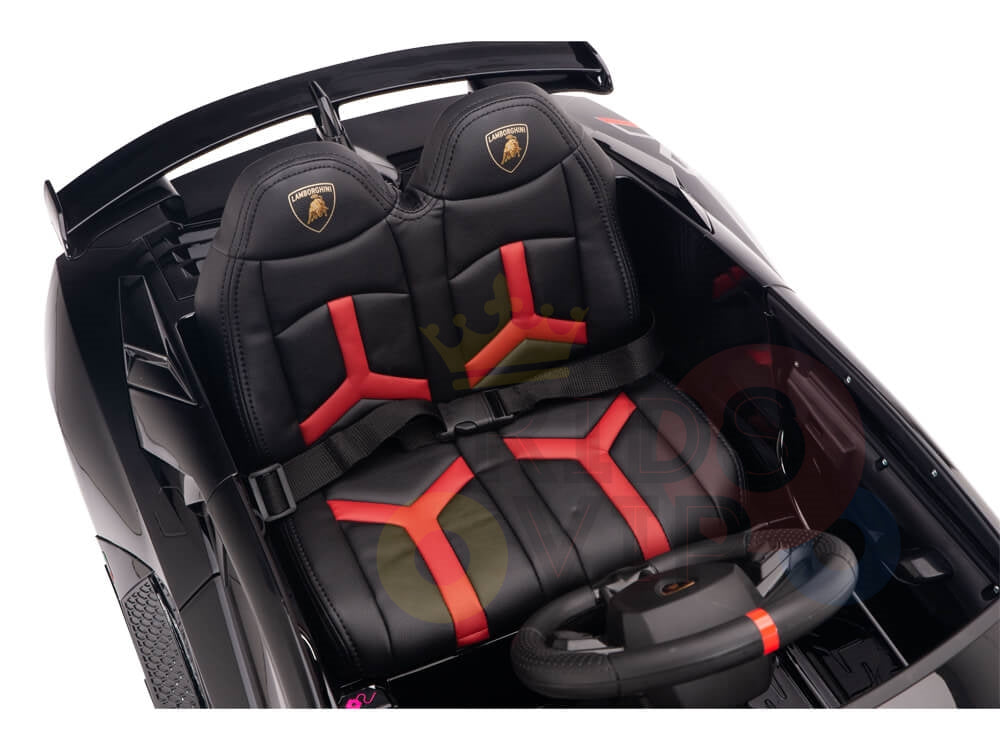 The Black 12V Lamborghini SVJ Sport Kids Licensed 1 Seater Ride On Car features luxury sports car styling with a black and red faux leather interior, detailed crest design, a small steering wheel, mock dashboard controls, rubber wheels, and offers the fun of remote control operation.