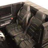 The Black 24V Mercedes Benz G63 Kids Ride On Car features two black plastic seats with detailed stitching and harness-style seat belts, a matte black cabin with detailed moldings, and is powered by a 24V battery system.