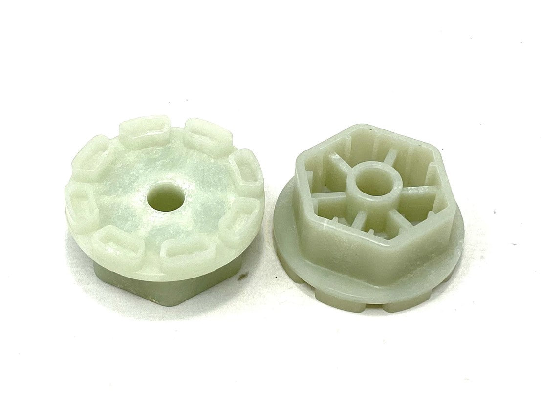 Two round, white plastic gears from the 24V Audi Q5 Set of Wheel Cogs lie on a plain white background. One gears teeth face up, while the other exposes its hexagonal design with inner spokes, resembling intricate cogs.