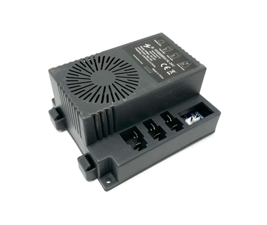 The black 24V 6X6 G63 Receiver is a rectangular device with a vented top and side ports, designed for ride-on cars. It has mounting brackets, printed safety info in white text, and displays CE and recycling symbols.