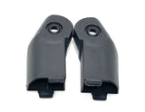 Two black plastic hinge covers, each with a circular hole at the top and a protruding tab at the bottom, resemble components from a larger mechanism. They might be similar to those found in the Set Of Mirror Clips for a 24V Tundra XXL ride-on car.