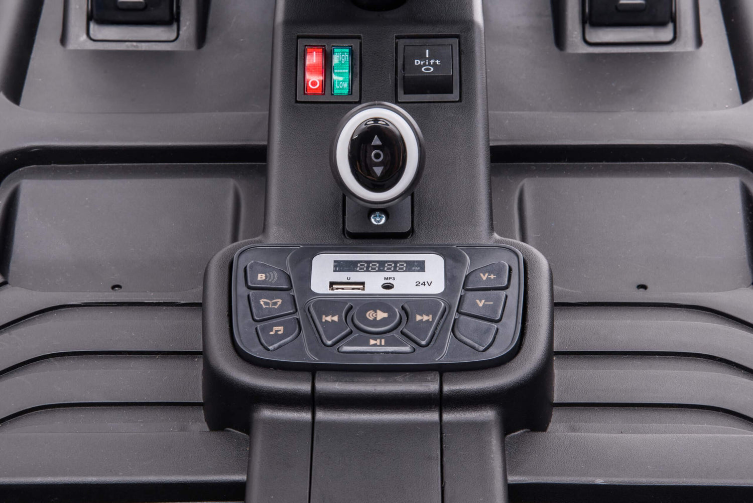 Close-up of the Blue Big Kids 24 Volt Ultra-Violent Complete Edition Drifting Go-Kart dashboard with a digital display, volume and playback controls, key slot, USB port, power switches, and EVA-rubber wheels for smooth handling. Labels show play, pause, and volume functions.