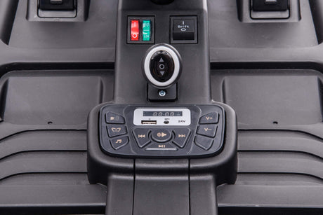 Close-up of the Blue Big Kids 24 Volt Ultra-Violent Complete Edition Drifting Go-Kart dashboard with a digital display, volume and playback controls, key slot, USB port, power switches, and EVA-rubber wheels for smooth handling. Labels show play, pause, and volume functions.
