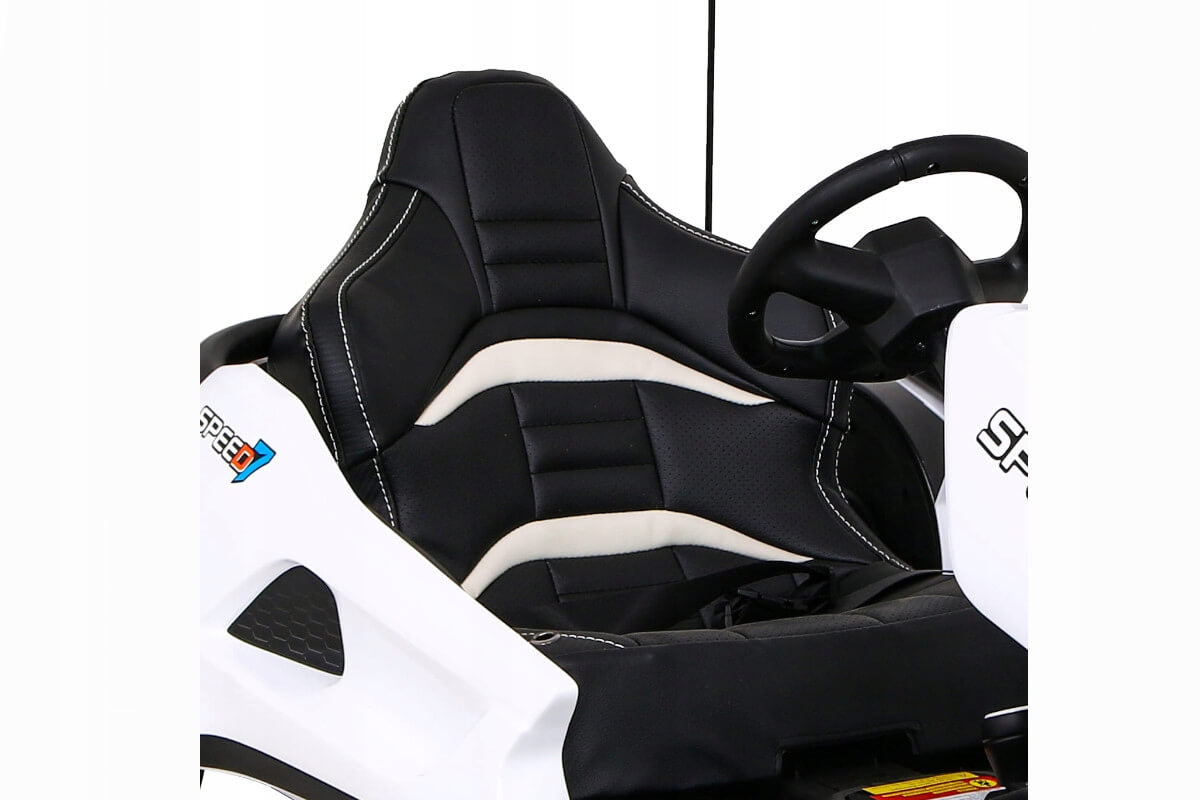 A close-up of a black and white racing seat with detailed stitching in a toy car, partially revealing the steering wheel on the right. This sporty plush-look seat is part of the edgy Big Kids 24 Volt Ultra-Violent Complete Edition Drifting Go-Kart.