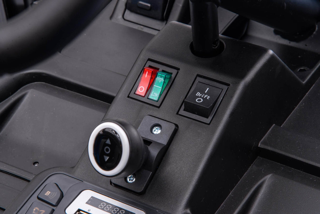 Close-up of the Big Kids 24 Volt Ultra-Violent Complete Edition Drifting Go-Kart control panel with red and green toggle switches set to On, Drift mode to Off, and a circular charging port. Brace for exciting rides this go-kart promises!.