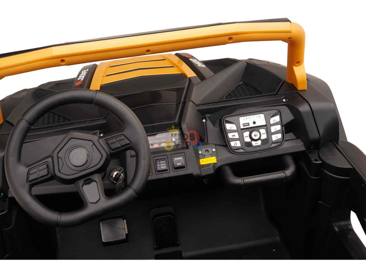 The toy car dashboard close-up echoes the Gold 2 Seater XXL Blade XR Edition 24V 180W Ride On Buggy UTV, featuring a steering wheel, electronic display, and control buttons. Its black surroundings with yellow accents capture the excitement of the XXL Blade XR ride.