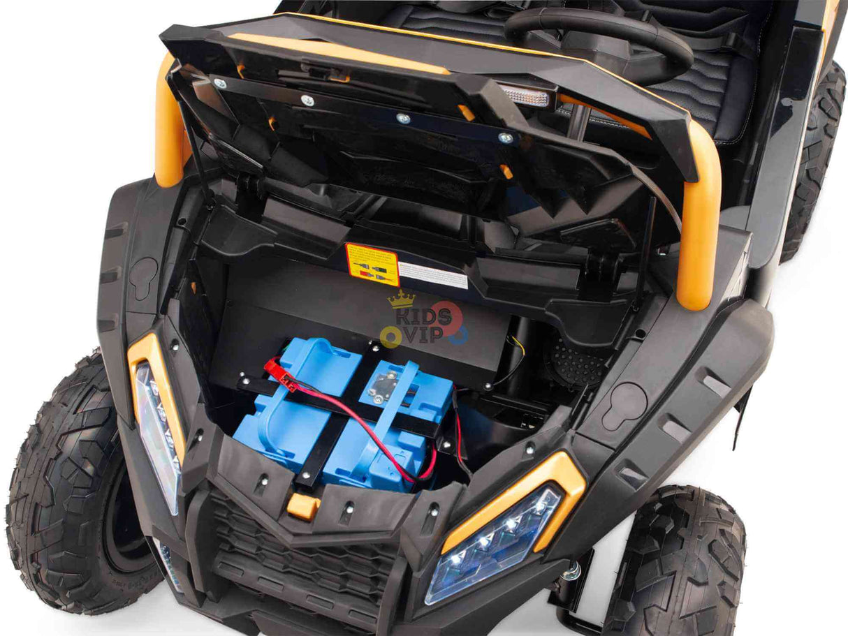 The Gold 2 Seater XXL Blade XR Edition 24V 180W Ride On Buggy UTV features a sleek black body with orange accents and rugged wheels. An open front hood unveils a blue battery, and its visible steering wheel completes the adventurous ride. No RC included.