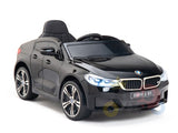 The Black Licensed BMW GT 12V Kids Ride On Power Car features a glossy finish, detailed headlights, steering wheel, and single seat, capturing the sleek design of the official electric kids ride-on BMW.