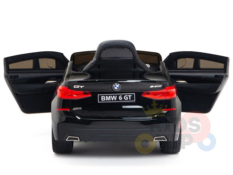 A rear view of the Black Licensed BMW GT 12V Kids Ride On Power Car with doors open highlights its realistic details and BMW 6 GT license plate on a white background, showcasing its upgraded features.