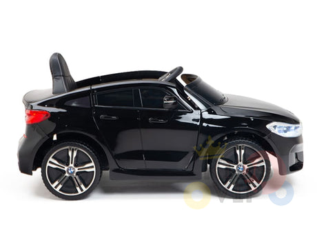 The Black Licensed BMW GT 12V Kids Ride On Power Car with Remote Control is a sleek black toy sports car featuring upgraded design elements, including a shiny exterior, detailed features, a small seat, steering wheel, and realistic wheels and headlights for an authentic driving experience.