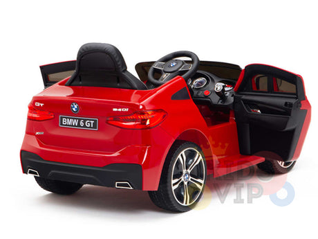 The Red 12V BMW GT Kids Licensed 1 Seater Ride-On Car features open doors, a black seat, and steering wheel like a real BMW 6 GT. It includes realistic gauges on the dashboard and BMW 6 GT on the rear, set against an elegant white background.