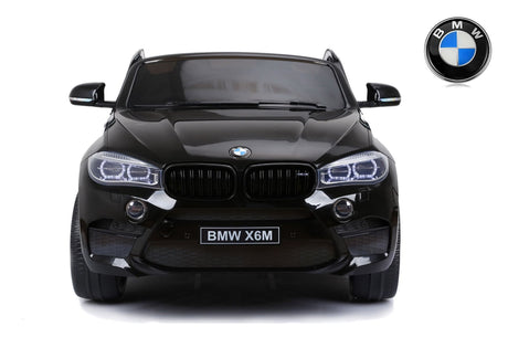 Front view of a Black 12V Licensed XXL BMW X6 Ride On Car with the BMW logo visible, featuring distinctive headlights and grille similar to a 2 Seater Ride On. The plain white background highlights its sleek and modern design akin to the BMW X6 Kids Ride On Car.