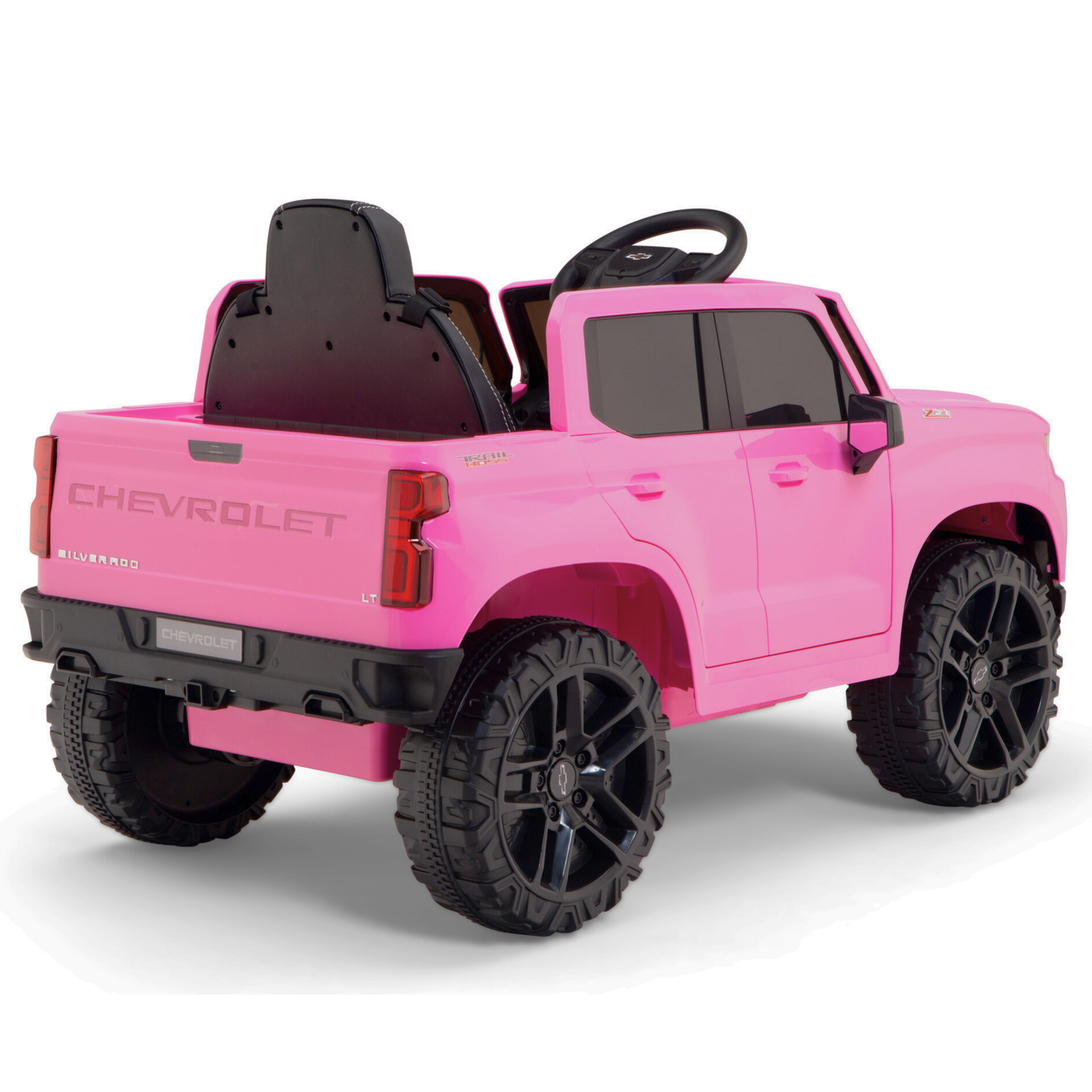 The Pink 12V Chevrolet Silverado kids licensed ride-on truck features large black wheels, realistic details like a steering wheel and seating area, and is perfect for young drivers. Model viewed from the rear left side.