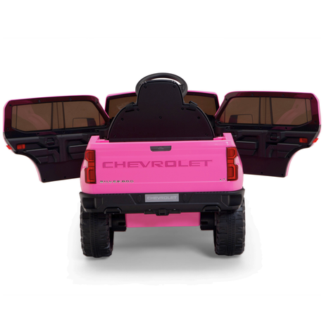 The Pink 12V Chevrolet Silverado Kids Licensed Ride-On Truck features black wheels, tinted windows, rear view with closed tailgate and open doors. This one-seater includes a remote control for extra fun.